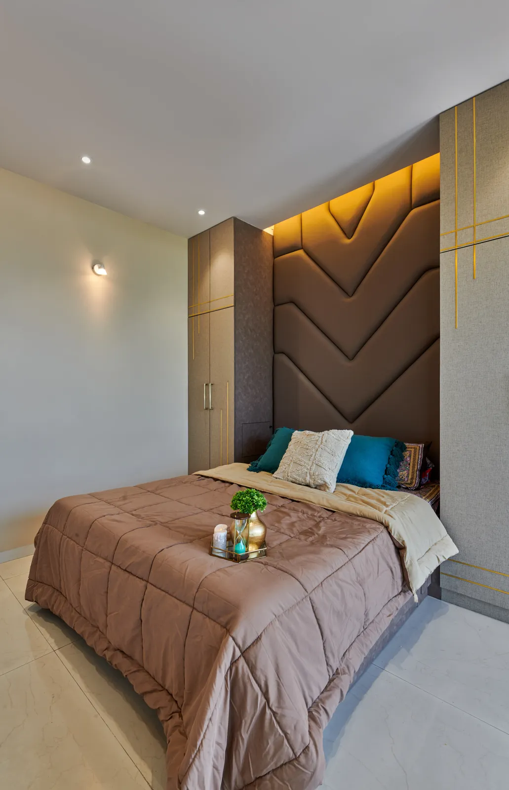 Bedroom 2 exudes sophistication with a brown, chevron-patterned headboard and sleek wardrobes accented with gold trims.