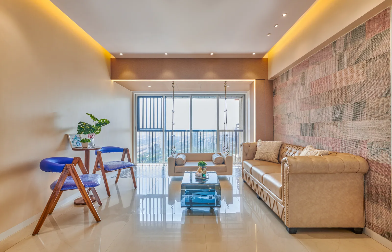 The living room exudes contemporary elegance with a beige tufted leather sofa, a hanging swing chair, and a textured feature wall.