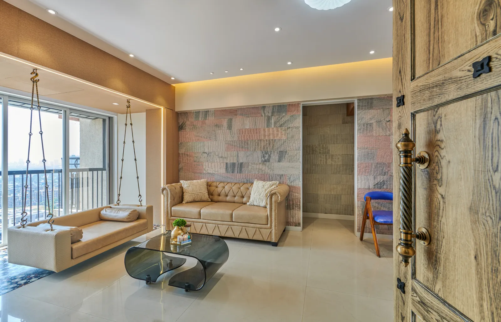 A dynamic interplay of textures in the living room, with the tufted sofa, textured feature wall, and hanging swing chair creating a visual feast.